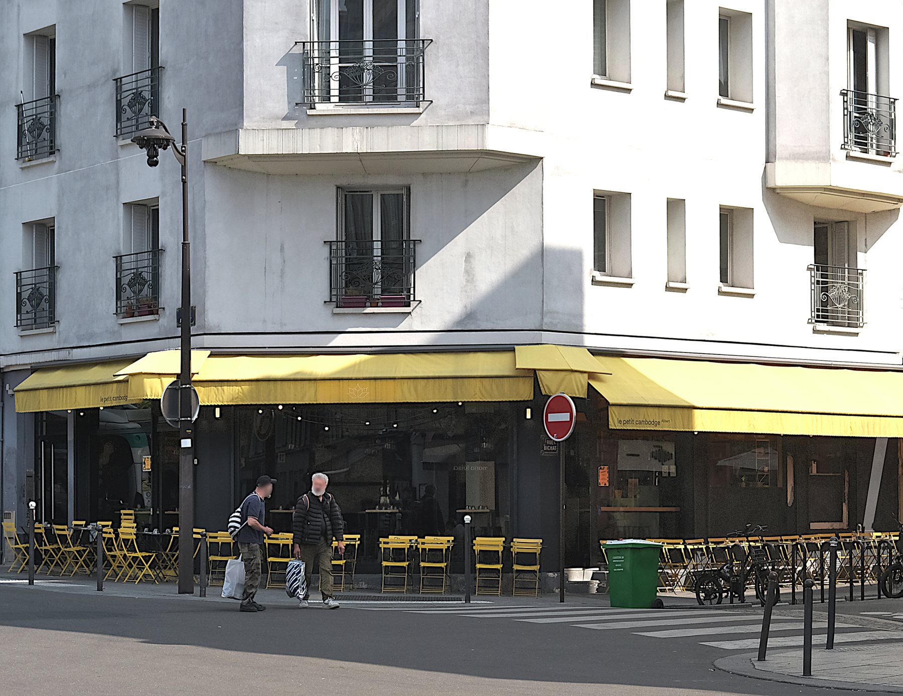 Stores jaunes et tables du Petit Cambodge rue Alibert, en 2024